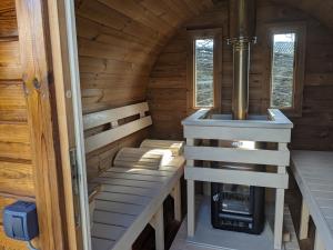 a sauna with a stove in a wooden cabin at Luxe glamping "De Steenuil" met sauna in Volkel