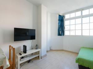 ein Wohnzimmer mit einem TV an einer weißen Wand in der Unterkunft Apartamento Pura vida con WIFI Playas y compras in Vecindario