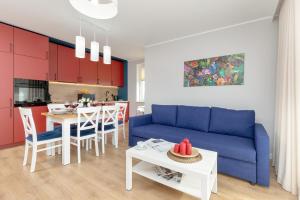sala de estar con sofá azul y mesa en Beautiful & Spacious 2 Bedroom Apartment Mickiewicza by Renters, en Puck