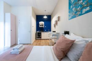 um quarto com uma cama branca com almofadas e uma cozinha em Aparthotel North Studio With Patio For 2 em Amesterdão