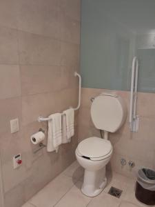 een badkamer met een wit toilet en handdoeken bij Dazzler by Wyndham Rosario in Rosario