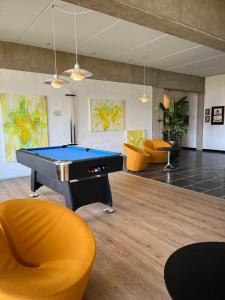 a pool table in a room with orange chairs at Toppen af Ebeltoft in Ebeltoft