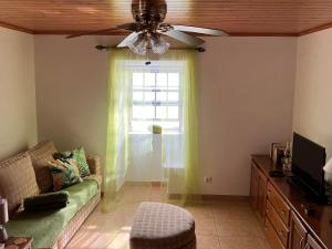 a living room with a couch and a window at Vistalinda Farmhouse in Fajã dos Vimes