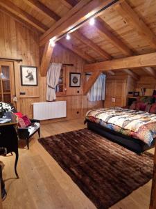 Un dormitorio con una cama grande en una habitación con techos de madera. en Chalet de 4 chambres avec jacuzzi terrasse et wifi a Megeve a 2 km des pistes, en Megève