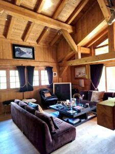 sala de estar con sofá y mesa en Chalet de 4 chambres avec jacuzzi terrasse et wifi a Megeve a 2 km des pistes, en Megève