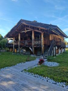 une grande cabane en rondins avec une véranda et une terrasse. dans l'établissement Chalet de 4 chambres avec jacuzzi terrasse et wifi a Megeve a 2 km des pistes, à Megève