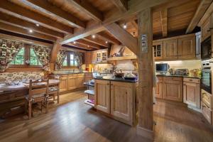 a large kitchen with wooden cabinets and a table at Chalet de 4 chambres avec jacuzzi terrasse et wifi a Megeve a 2 km des pistes in Megève