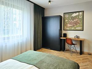 sypialnia z łóżkiem, biurkiem i oknem w obiekcie visit baltic - Rezydencja Sienkiewicza Loft przy plaży w Świnoujściu