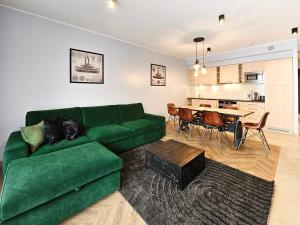salon z zieloną kanapą i stołem w obiekcie visit baltic - Rezydencja Sienkiewicza Loft przy plaży w Świnoujściu