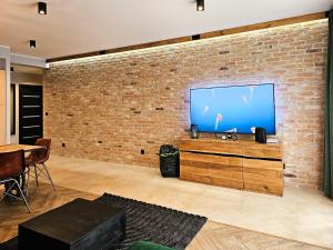 ceglana ściana z telewizorem z płaskim ekranem w obiekcie visit baltic - Rezydencja Sienkiewicza Loft przy plaży w Świnoujściu