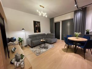- un salon avec un canapé, une table et des chaises dans l'établissement Apartament nad jeziorem Długim Leśna # 32, à Olsztyn