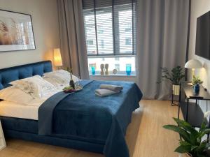 - un lit bleu dans une chambre avec fenêtre dans l'établissement Apartament nad jeziorem Długim Leśna # 32, à Olsztyn