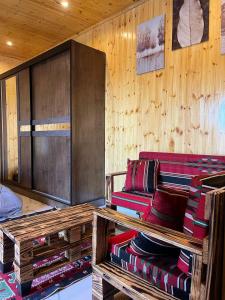 Cette chambre est dotée de murs en bois et d'un canapé avec des oreillers. dans l'établissement white tulips studio, à Jerash