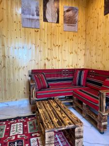 - un salon avec des murs en bois et des canapés en bois dans l'établissement white tulips studio, à Jerash