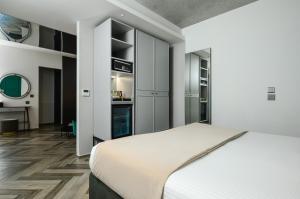 a bedroom with a white bed and a desk at The Embassy Valletta Hotel in Valletta