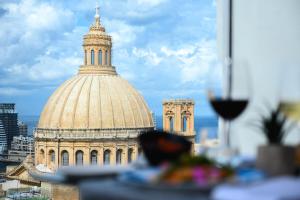 a large building with a tower on top of it at The Embassy Valletta Hotel in Valletta