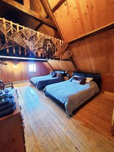 1 dormitorio con 2 camas y techo de madera en Auberge Le P'tit Bonheur, en Saint-Laurent-de-l'ile d'Orleans