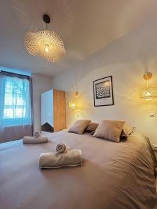 ein Schlafzimmer mit einem großen Bett mit Handtüchern darauf in der Unterkunft Le Paisiblement Vôtre 3 Ch, Terrasse, Clim, Park in Montauban