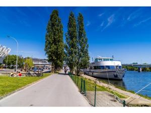a boat is docked next to a path next to a river at Cosy Room in Remich in Remich