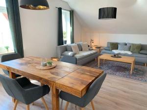 uma sala de estar com uma mesa de madeira e cadeiras em Apartment Elisa em Osnabrück