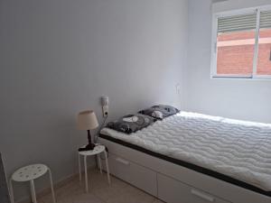 um quarto branco com uma cama e uma janela em PUERTO BENICARLÓ em Benicarló