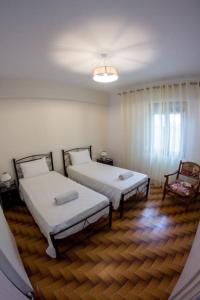 a room with two beds and a chair at Spacious Apartment in the heart of Pythagorion in Pythagoreio