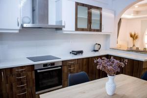 a kitchen with a wooden table and a vase with flowers at Spacious Apartment in the heart of Pythagorion in Pythagoreio