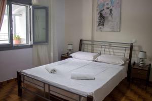 a bedroom with a large bed with white sheets at Spacious Apartment in the heart of Pythagorion in Pythagoreio