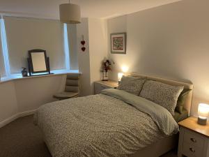 Schlafzimmer mit einem Bett, einem Fenster und einem Spiegel in der Unterkunft Beautiful 2-Bed Apartment near Lincoln City Centre in Lincoln