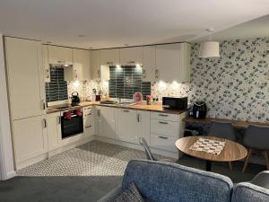 a kitchen with white cabinets and a table at Beautiful 2-Bed Apartment near Lincoln City Centre in Lincoln