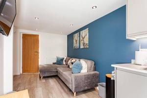 un soggiorno con divano e parete blu di One bedroom apartment, Driveway, Bracknell Centre a Bracknell