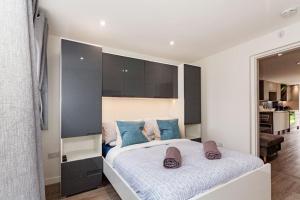 One bedroom apartment, Driveway, Bracknell Centre في براكنيل: غرفة نوم بسرير كبير مع وسائد زرقاء