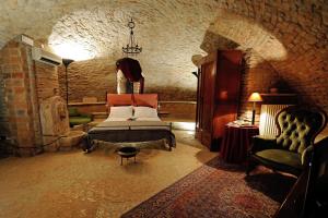 マントヴァにあるカーサ ムゼオ パラッツォ ヴァレンティ ゴンザーガのベッドルーム1室(ベッド1台、椅子1脚付)