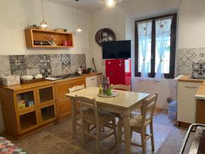 a kitchen with a table and a red refrigerator at Casa della Nonna in Porretta Terme