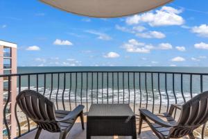 Beachfront Luxury Condo w Private Balcony في ميرتل بيتش: شرفة مع طاولة وكراسي والمحيط