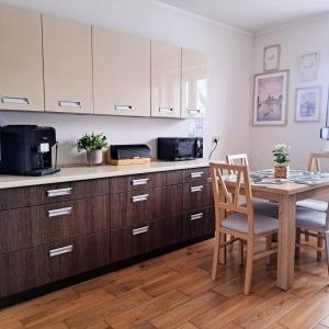 cocina con mesa de madera y microondas en Apartament pod Miastem, en Szamotuły