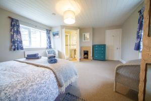a bedroom with a bed and a fireplace in it at Penrose Cottage in Bude