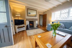 a living room with a blue couch and a fireplace at Penrose Cottage in Bude