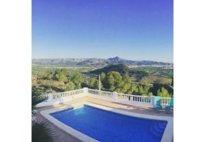 a swimming pool in front of a villa at Casa Romero in La Font D´En Carròs