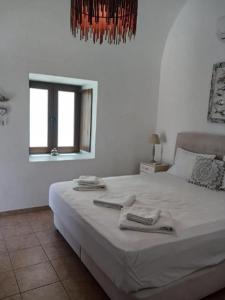 a bedroom with a large bed with towels on it at Beautiful Santorini Villa 1 Bedroom Suite Villa Laxus Pyrgos in Pyrgos