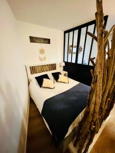 1 dormitorio con 1 cama hecha de ramas de árbol en L’Atelier des rêves à 200 m de la plage, en Fort-Mahon-Plage
