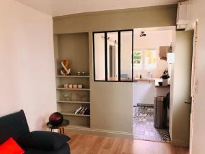 a living room with a couch and a kitchen at Maisonnette avec jardin proche Paris in Saint-Mandé