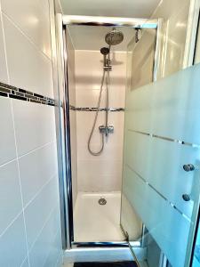 a shower with a glass door in a bathroom at Rare Parisian Architect House in Paris