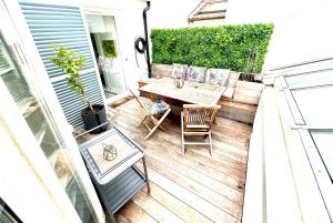 a small patio with a wooden table and chairs at Rare Parisian Architect House in Paris