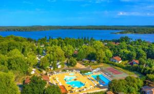 an aerial view of a resort with a pool and a lake at Vacances dans les Landes in Aureilhan