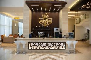 a lobby with a bar with a sign on the wall at Sun & Moon Bacca Hotel in Makkah