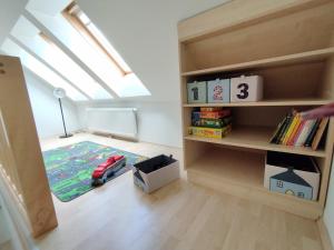 a room with a book shelf with a toy car on a rug at Ferienzimmer Reinisch in Tattendorf in Tattendorf