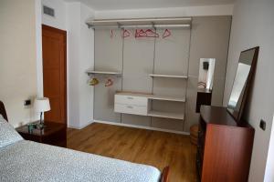 een slaapkamer met een bed, een dressoir en een spiegel bij La Finestra Blu Alba 2 in Alba