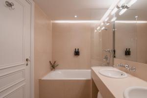 a bathroom with a tub and a sink and a shower at Hôtel De Buci in Paris