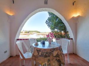 uma mesa num arco com uma mesa e cadeiras em Baja Sardinia Pool Residence em Baja Sardinia